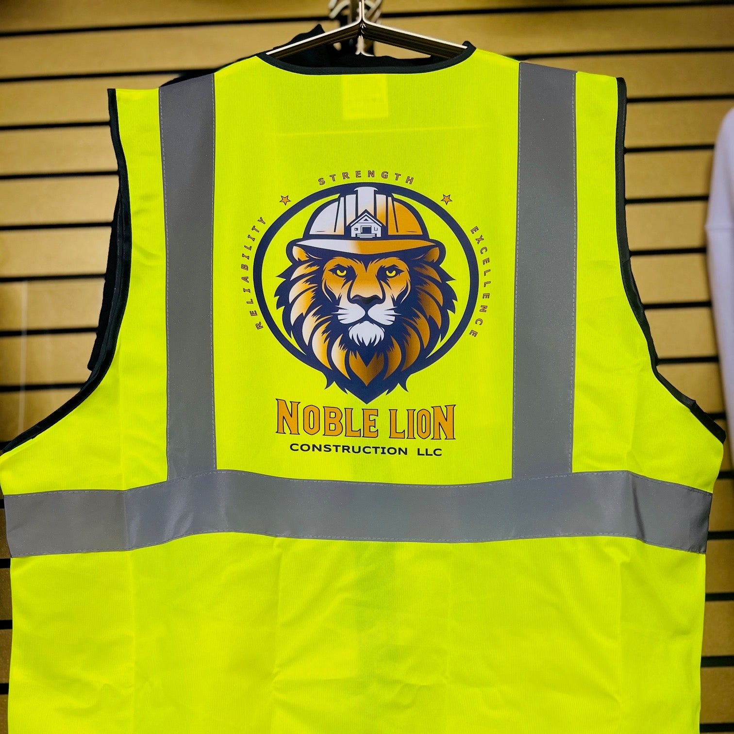 Yellow safety vest with a logo and text on a wooden background
